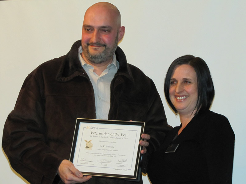 Dr. Ricardo Bonafine and Dr. Victoria Rojas holding BCSPCA award